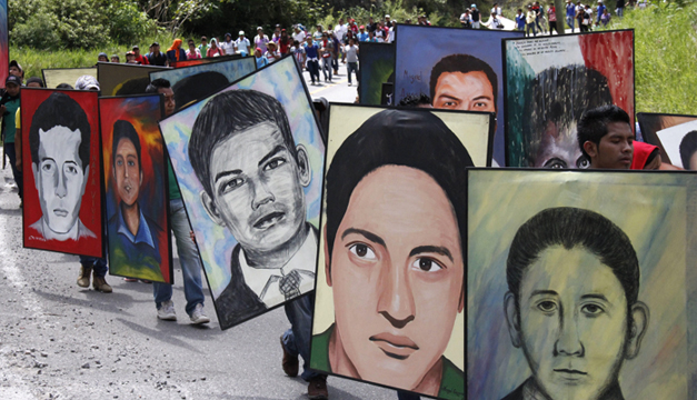 Normalistas de la escuela rural de Ayotzinapa sostienen retratos de los 43 estudiantes desaparecidos durante una caminata. Foto/EFE