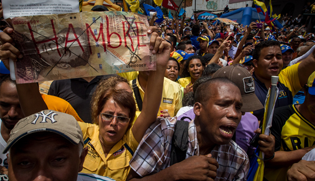 Manifestante sostiene un letrero con la palabra "Hambre" en una protesta contra el Gobierno venezolano. Foto: Agencia EFE