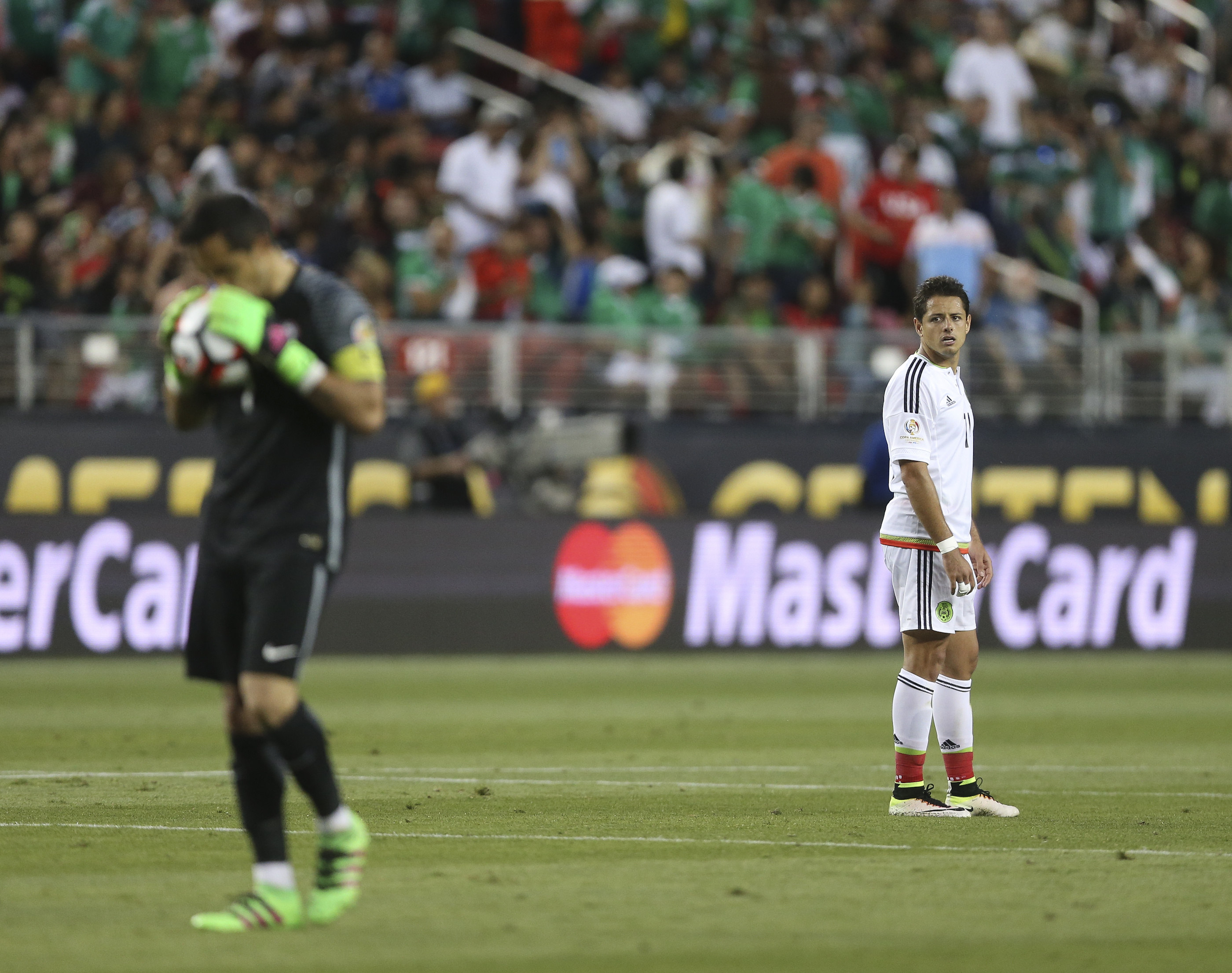 SCL68. SANTA CLARA (CA, EE.UU.), 18/06/2016.- El mexicano Javier Hernández (d) observa mientras el portero Claudio Bravo sostiene el balón hoy, sábado 18 de junio de 2016, durante un partido entre México y Chile por los cuartos de final de la Copa América Centenario, en el Levi's Stadium de Santa Clara, California (EE.UU.). EFE/David Fernández