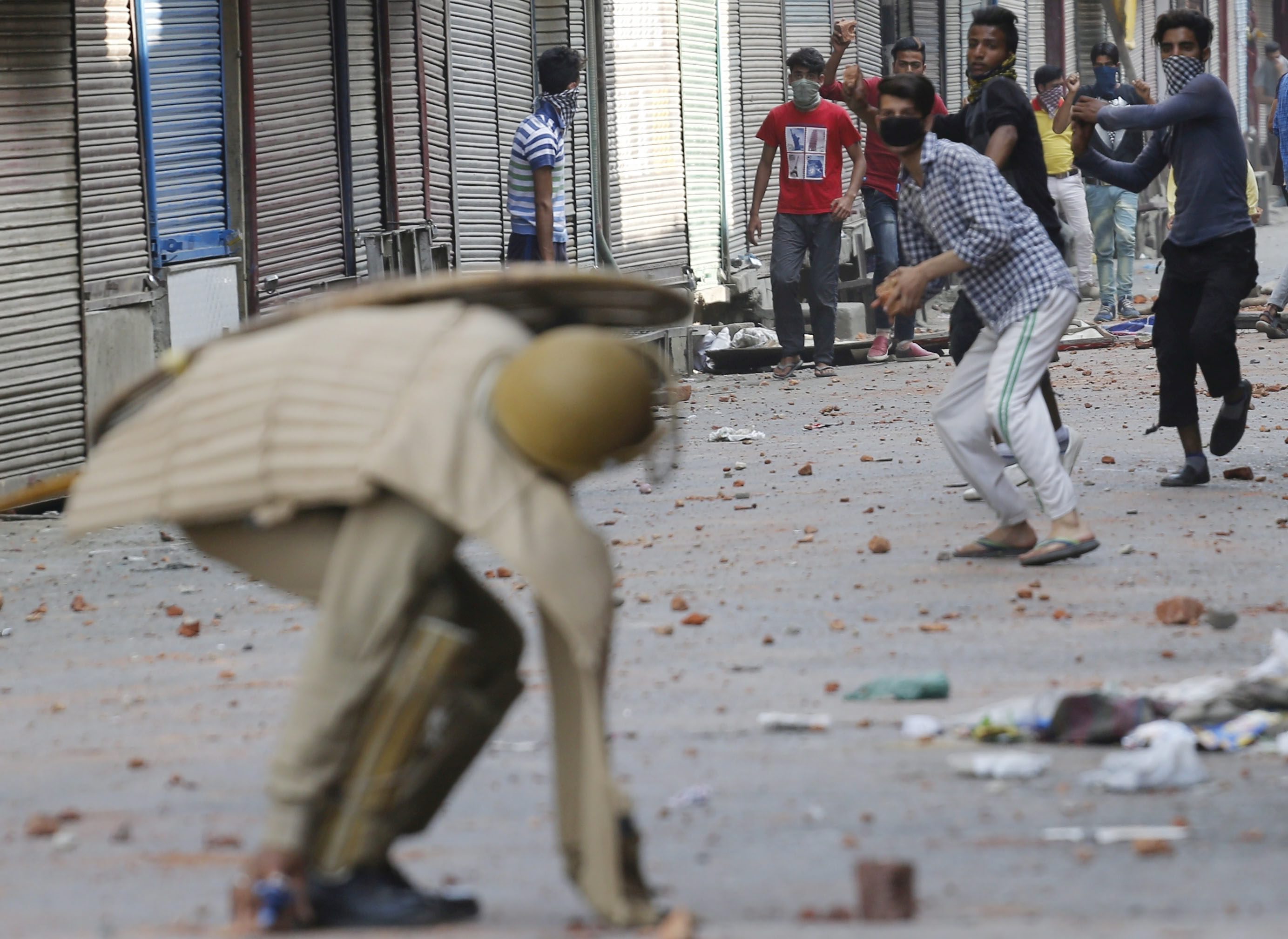 FAR02 SRINAGAR (INDIA) 11/07/2016.- Un grupo de manifestantes lanza piedras a un miembro de la policía durante una protesta violenta en Srinagar, la capital de verano de Cachemira, India hoy, 11 de julio de 2016. El número de muertos en protestas violentas en la Cachemira india se elevó ayer a 21 y el de heridos a cerca de 200, en el segundo día de disturbios en la región por la fallecimiento el viernes de un terrorista del grupo separatista Hizb-ul-Mujahideen (HM) a manos de las fuerzas de seguridad. En Srinagar hay calles, desiertas, cortadas con alambres de espino en las que montan guardia efectivos de las fuerzas de seguridad indias armados con fusiles. EFE/Farooq Khan