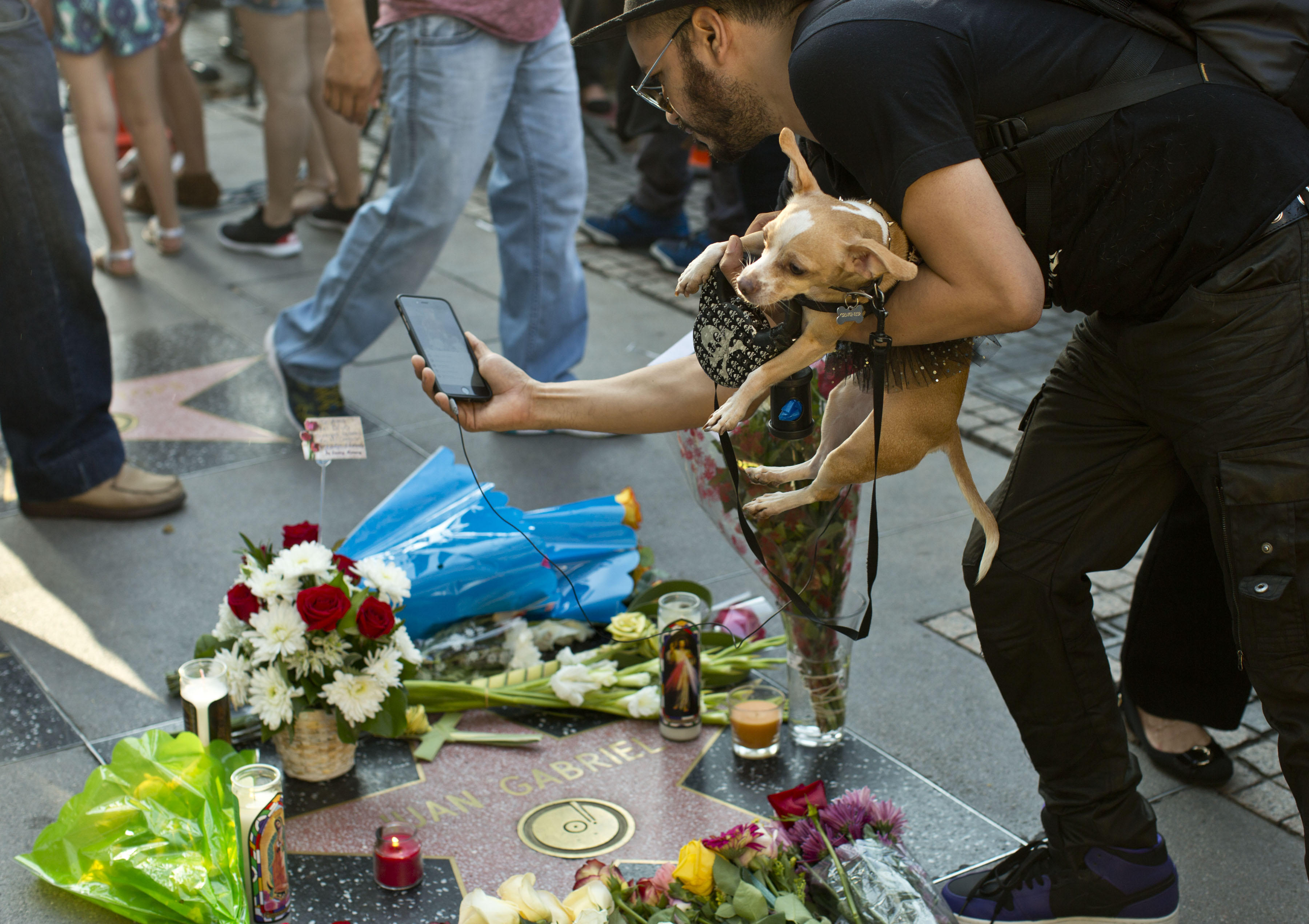 EUA01. HOLLYWOOD (EEUU), 28/08/2016.- Un grupo de personas rinden tributo al cantante Juan Gabriel, una de las estrellas musicales más importantes de México, en su estrella en el Paseo de la Fama en Hollywood (Estados Unidos). El presidente de México, Enrique Peña Nieto, y medios locales informaron hoy del fallecimiento del divo mexicano a los 66 años debido a un infarto al corazón, dos días después de dar su último concierto en el Fórum de Los Ángeles. EFE/RODOLFO DE LUNA