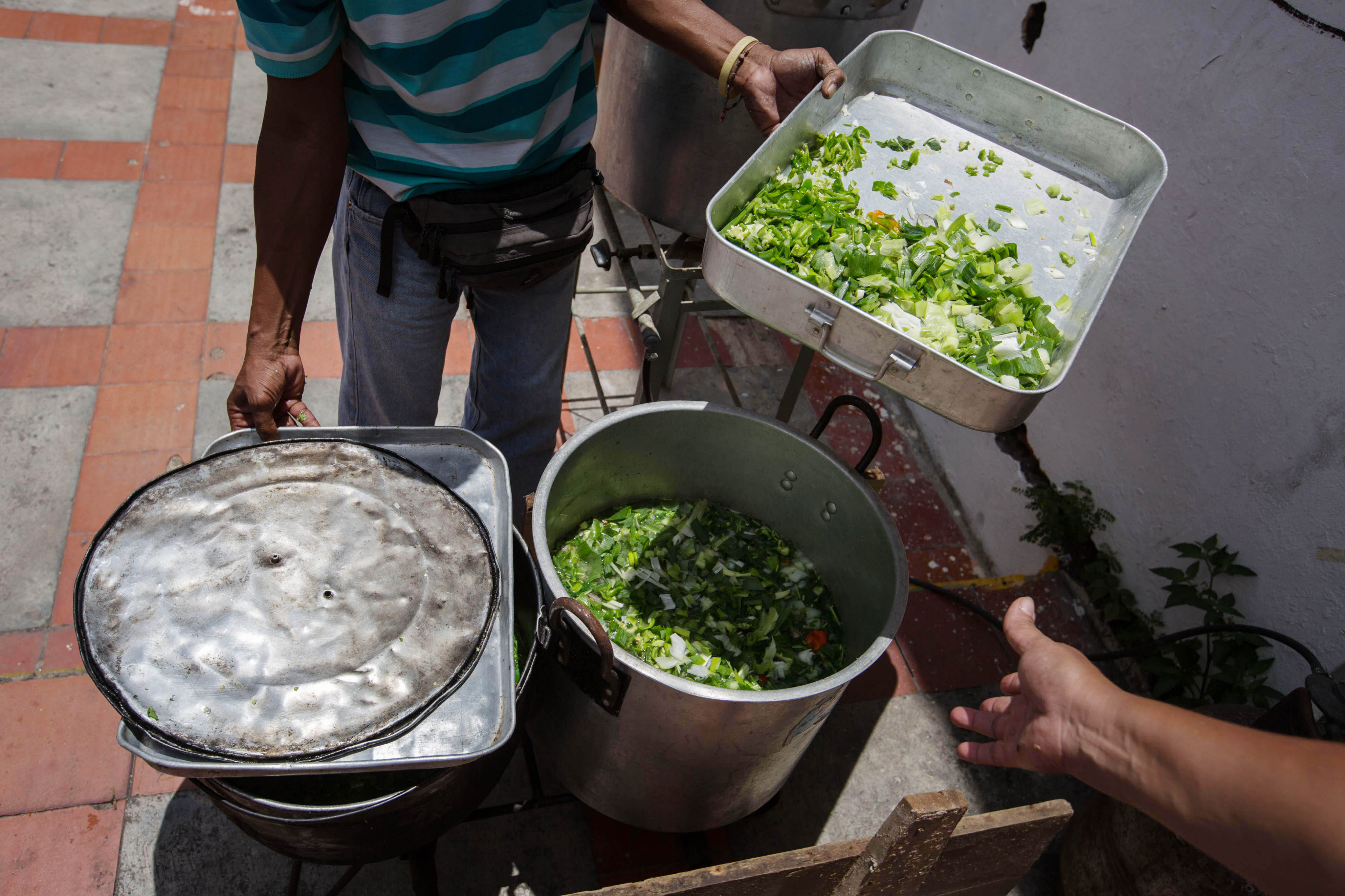CAR01. CARACAS (VENEZUELA), 10/09/2016.- Un grupo de personas preparan un sancocho hoy, s·bado 10 de septiembre del 2016, en la ciudad de Caracas (Venezuela). En el barrio la UniÛn, ubicado en la favela m·s grande de AmÈrica Latina asentada en el este de Caracas, se preparÛ hoy un gran "sancocho" como se le conoce en Venezuela a la sopa cocinada con varios tipos de verduras y carnes, para alimentar a los vecinos, muchos de ellos con varios dÌas de hambre. EFE/MIGUEL GUTI…RREZ