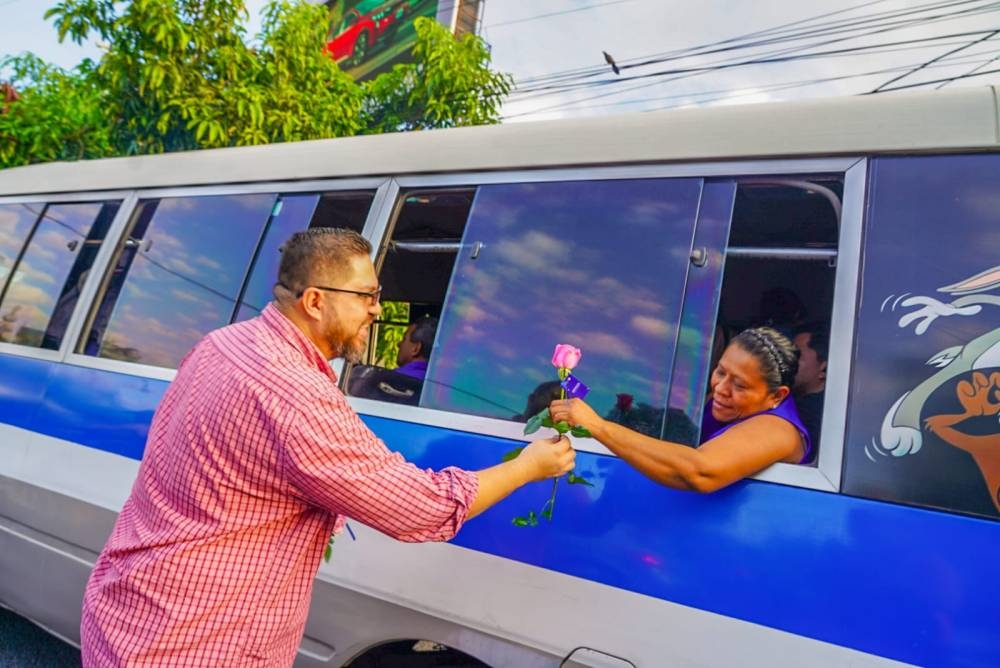 Peatones y conductores que transitan en los alrededores de la Plaza Salvador del Mundo son los primeros en recibir una rosa. / Prensa de San Salvador Centro.