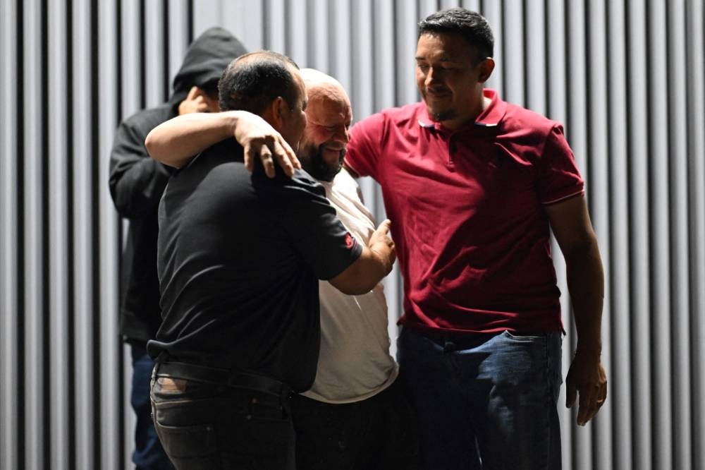 Una videollamada con familiares de José Maximino Amaya, un migrante salvadoreño deportado de Estados Unidos, se ve en un teléfono móvil mientras su familia lo espera afuera del Centro de Atención al Migrante Retornado en San Salvador el 26 de febrero de 2025. Marvin Recinos / AFP
