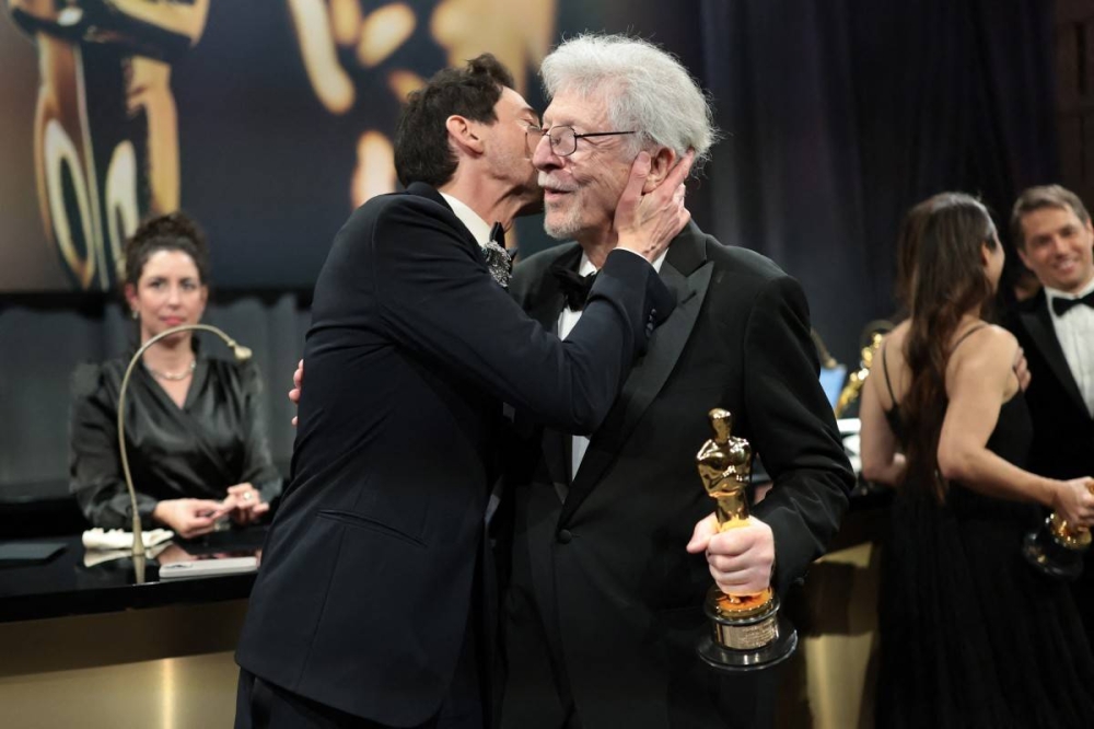 Adrien Brody le da un beso a su padre, Elliot, tras ganar su segundo Óscar por “El Brutalista”. Photo by Monica Schipper / GETTY IMAGES NORTH AMERICA / Getty Images via AFP