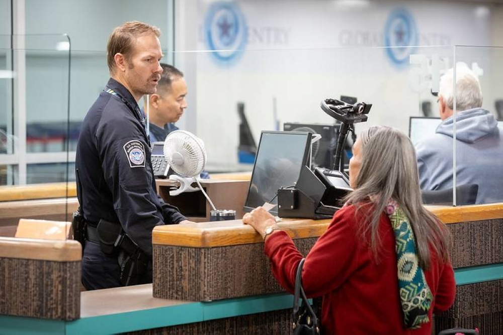 Un oficial de Migración estadounidense atiende a una pasajera en el aeropuerto de Phoenix, Arizona./DHS