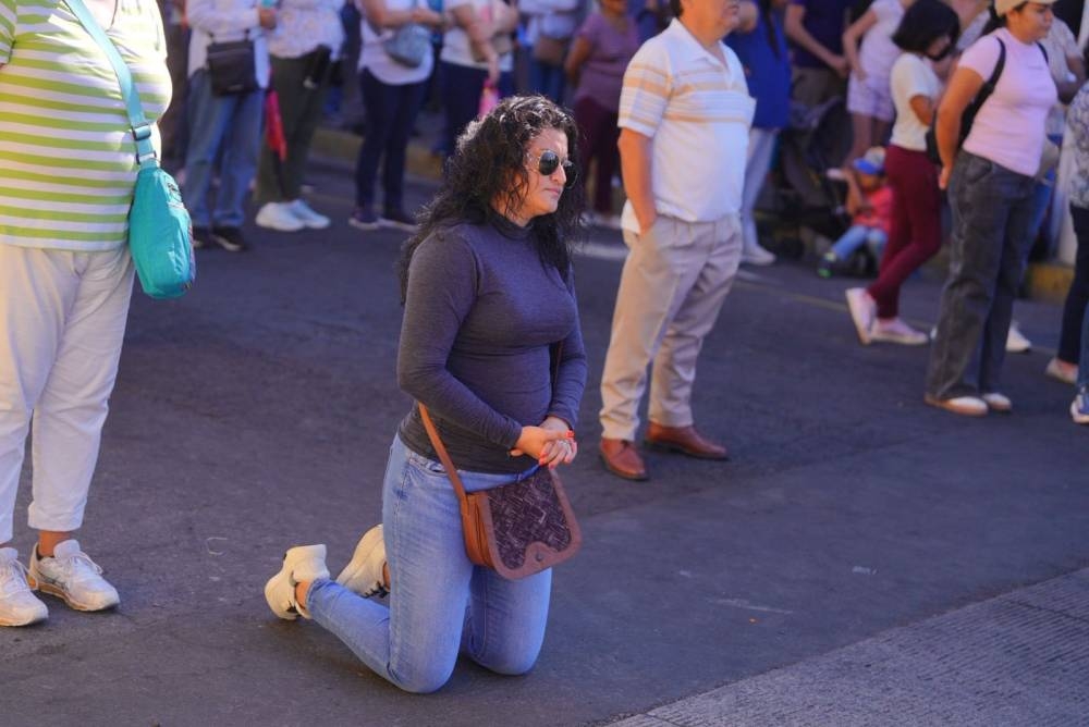 Algunos devotos se arrodillan cuando pasó el viacrucis, que recuerda el camino de Jesús a la crucifixión. /Alcaldía de La Libertad Sur