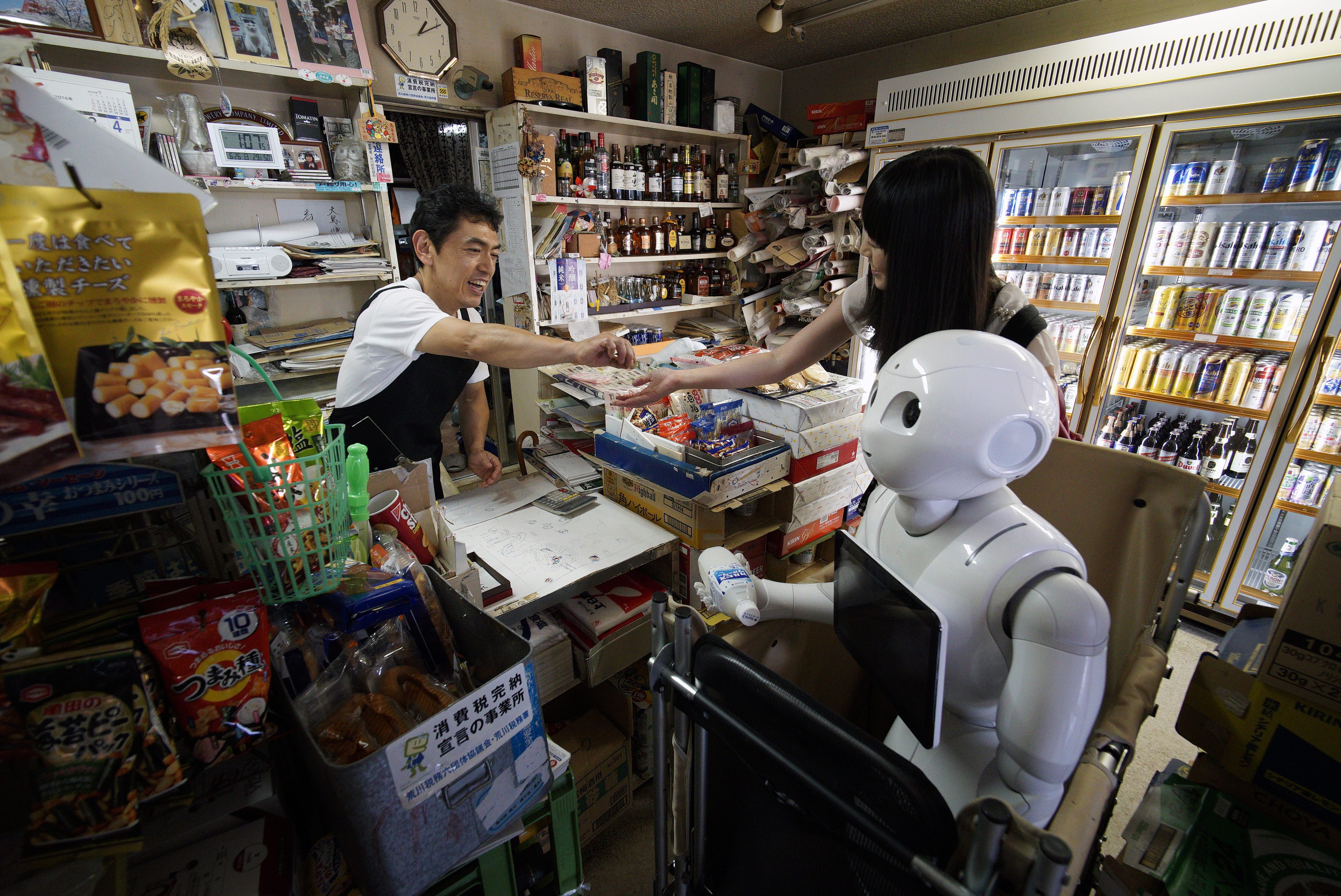 FRA47. Tokyo (Japan), 26/06/2016.- (07/21) Tomomi Ota (R) buys a soft drink with her humanoid robot Pepper at a local shop in Tokyo, Japan, 26 June 2016. Reaching 120cm in height and 28 kilograms in weight, Pepper does not enter in the category of 'Äòportable'Äô robot. But those characteristics don'Äôt stop Tomomi Ota to take Pepper in a cart to stroll in her neighborhood, go shopping or even take the subway. In June 2014, when Pepper was presented for the first time by Japanese telecommunications and Internet corporation Softbank at a press event, Tomomi looked at the presentation via a live broadcast on Ustream. While some people were 'Äòscared'Äô or reluctant by the new humanoid robot, curiosity pushed her to apply to lottery sales for the first lot of 200 Pepper. She was lucky enough to acquire then a 'ÄòDeveloper'Äôs Pepper'Äô, the first models of the robots which need to be programmed by the users. Pepper entered Tomomi'Äôs home in November 2014 and was soon adopted by her parents to become a member of the family. Having degrees in media design and music, Tomomi had to learn programming and her efforts deepened her bonds with her new friend. Capable of reading human emotions and to adapt to his interlocutor, the robot created by Aldebaran Robotics and SoftBank Robotics is now used as customer service in stores and 1000 units are sold out in minutes after being on sale every month. Pepper is making his way to Japanese homes but few can enjoy so much outdoor like Tomomi'Äôs one. Asked if she isn'Äôt worried about damaging her robot friend during her activities, the 30-year-old said that she is taking extra care as she couldn'Äôt imagine being separated two months from Pepper, the average time needed for a repair. (Tokio, Japón) EFE/EPA/FRANCK ROBICHON PLEASE REFER TO THE ADVISORY NOTICE (epa05406529) FOR FULL PACKAGE TEXT